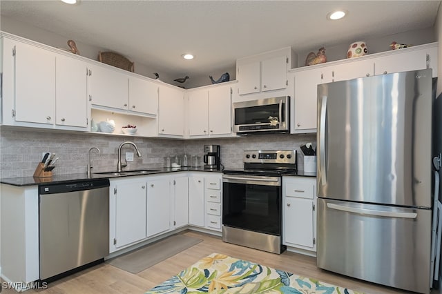 kitchen with appliances with stainless steel finishes, sink, and white cabinets