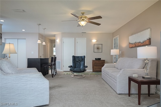 carpeted living room with ceiling fan