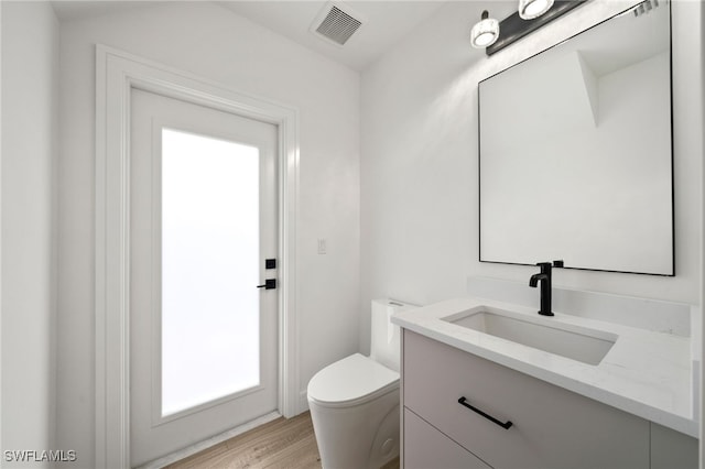 bathroom featuring hardwood / wood-style floors, vanity, and toilet