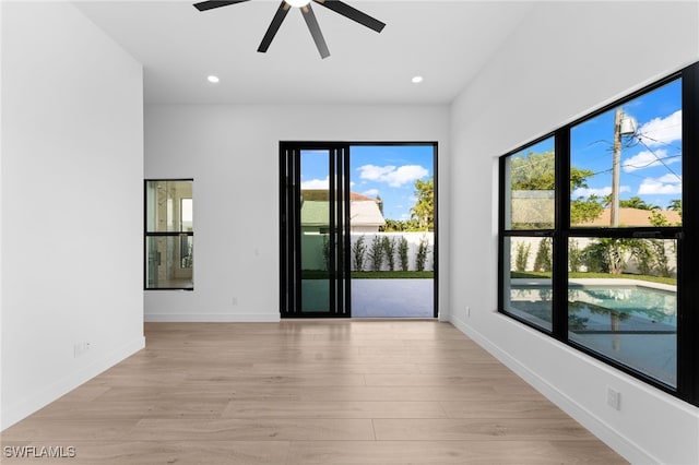 unfurnished room with light hardwood / wood-style floors, a wealth of natural light, and ceiling fan