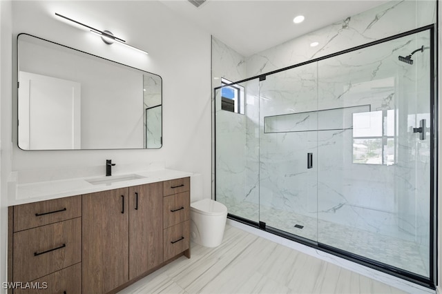 bathroom with walk in shower, vanity, and toilet