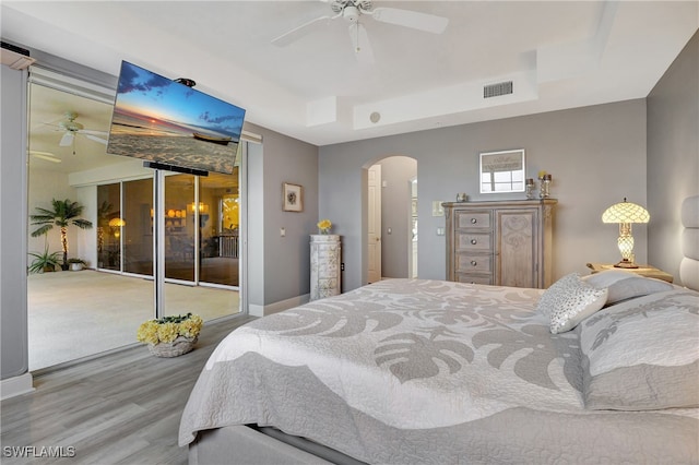 bedroom with access to outside, wood-type flooring, and ceiling fan