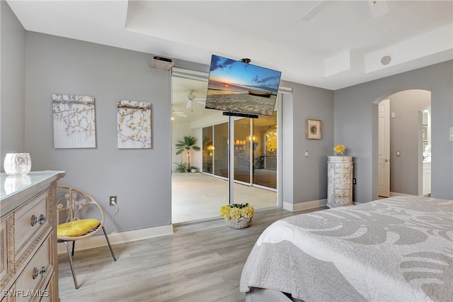 bedroom with access to exterior, light wood-type flooring, and ceiling fan