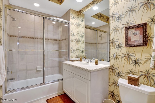 full bathroom with vanity, shower / bath combination with glass door, and toilet