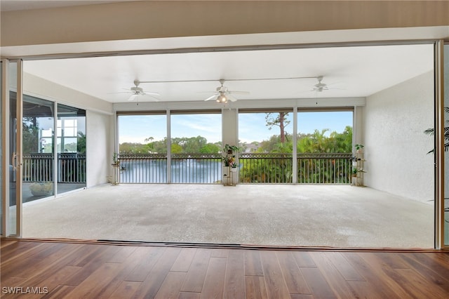 unfurnished sunroom featuring a water view