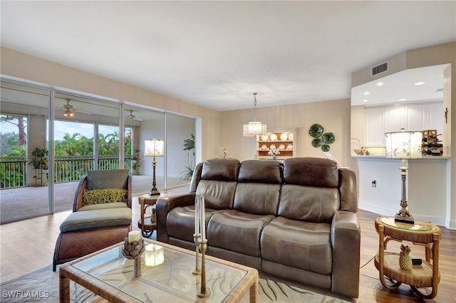 living room featuring ceiling fan and light hardwood / wood-style flooring