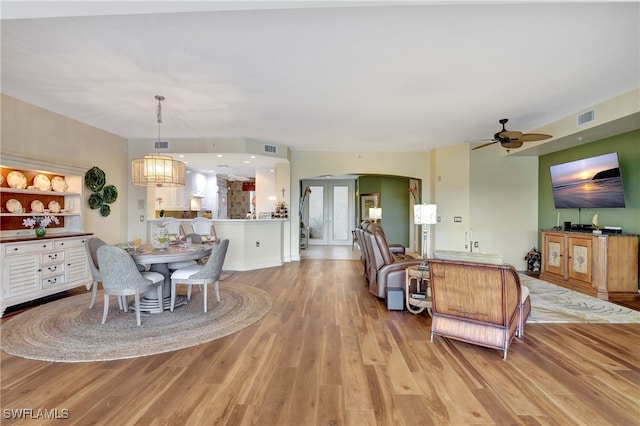 dining area featuring light hardwood / wood-style floors and ceiling fan with notable chandelier