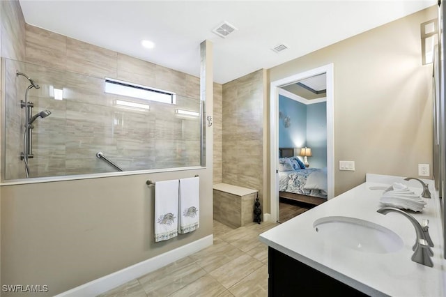 ensuite bathroom featuring double vanity, visible vents, connected bathroom, a sink, and walk in shower