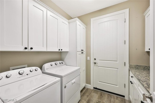 laundry area with cabinet space, wood finished floors, and independent washer and dryer