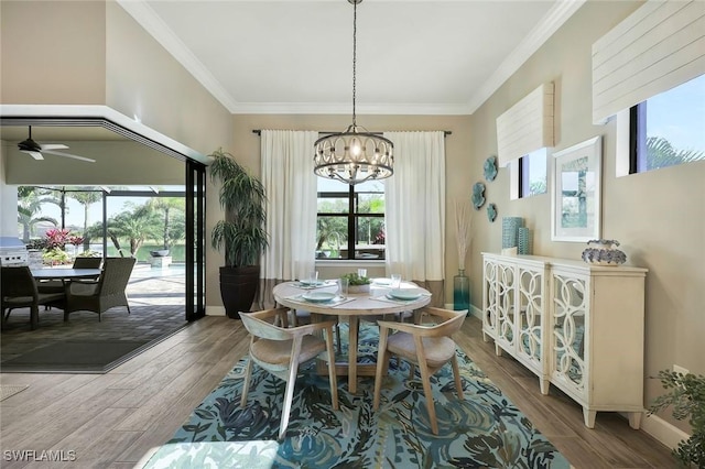 dining space featuring baseboards, ornamental molding, wood finished floors, and ceiling fan with notable chandelier