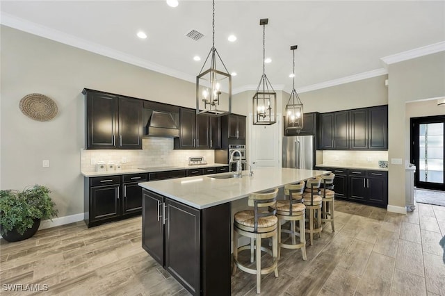 kitchen featuring custom exhaust hood, stainless steel appliances, visible vents, light wood-style floors, and a sink