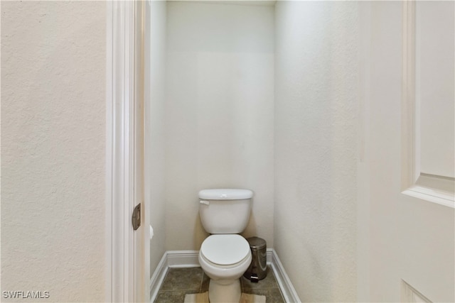 bathroom with toilet and tile patterned flooring