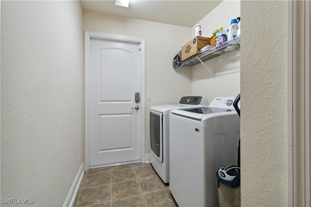 clothes washing area with independent washer and dryer and dark tile patterned floors