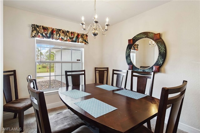 carpeted dining area with a chandelier