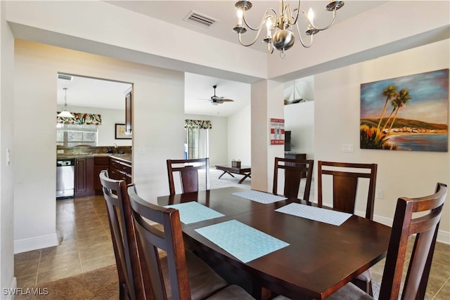 tiled dining room featuring sink and ceiling fan with notable chandelier