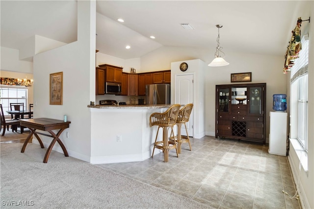 kitchen with lofted ceiling, kitchen peninsula, appliances with stainless steel finishes, pendant lighting, and light colored carpet