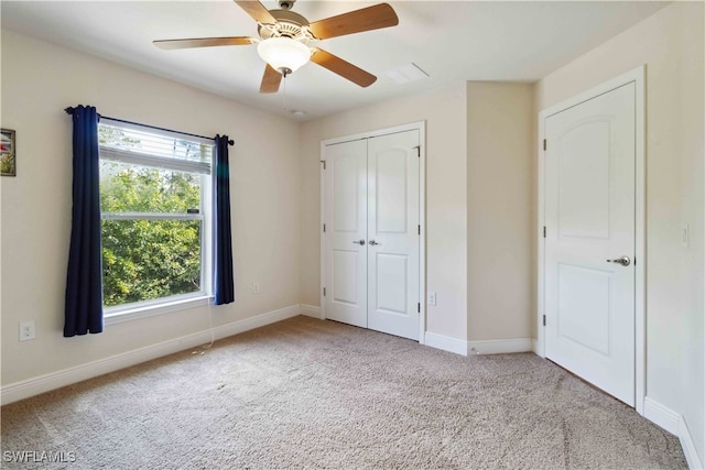 unfurnished bedroom featuring light colored carpet, a closet, and ceiling fan