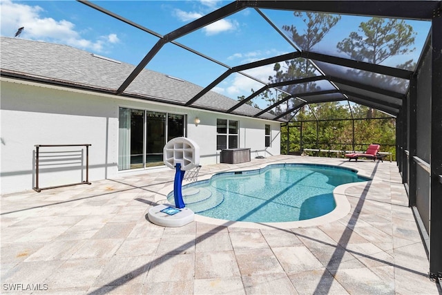 view of swimming pool featuring a patio area and glass enclosure