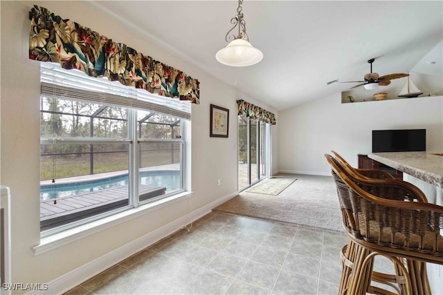 carpeted dining area featuring ceiling fan and lofted ceiling