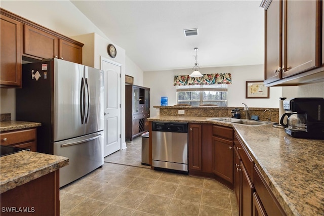 kitchen featuring lofted ceiling, hanging light fixtures, light tile patterned floors, sink, and stainless steel appliances