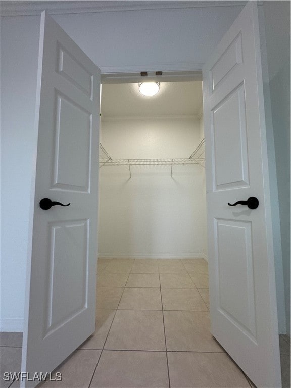 walk in closet with light tile patterned floors