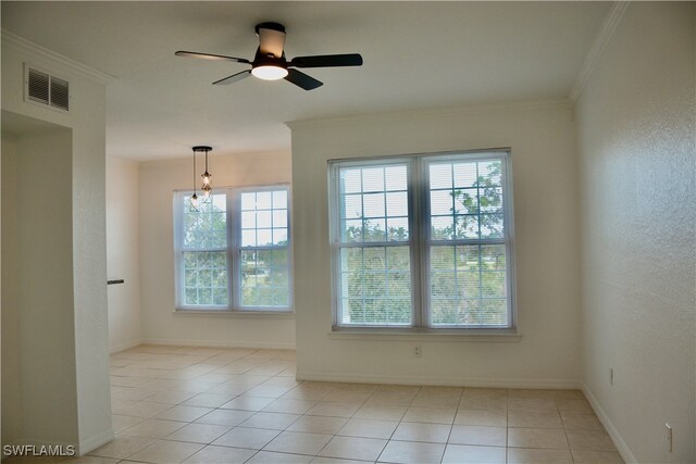 spare room featuring ornamental molding, ceiling fan, and light tile patterned floors