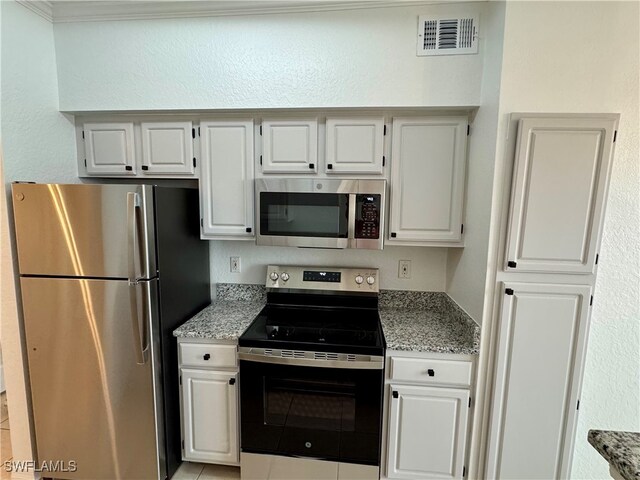 kitchen featuring light stone countertops, white cabinetry, and stainless steel appliances