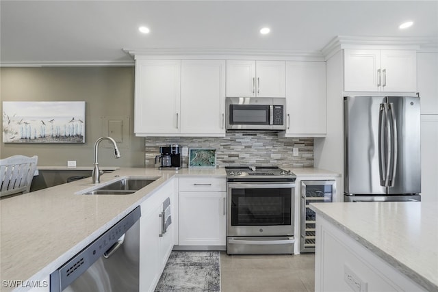 kitchen featuring white cabinetry, sink, beverage cooler, tasteful backsplash, and appliances with stainless steel finishes