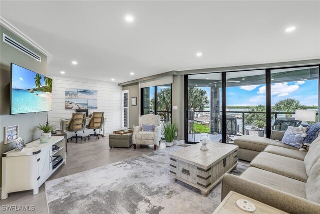 living room featuring floor to ceiling windows and wooden walls