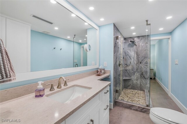 bathroom featuring vanity, toilet, and a shower with door