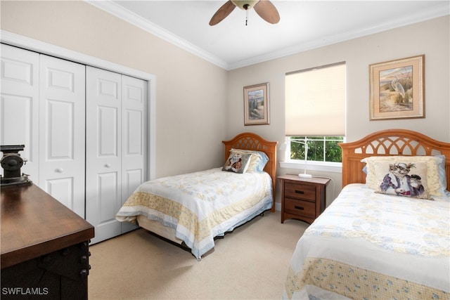 carpeted bedroom with ceiling fan, a closet, and ornamental molding