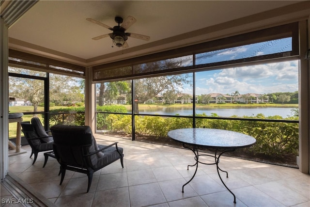 sunroom / solarium with ceiling fan and a water view