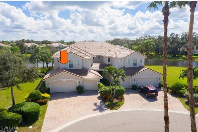 view of front of home with a garage, a water view, and a front yard