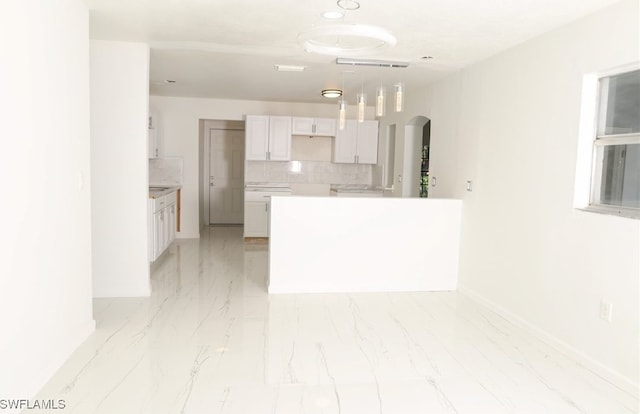 kitchen featuring white cabinets, hanging light fixtures, and backsplash