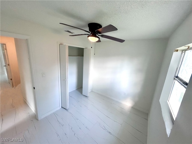 unfurnished bedroom with a textured ceiling and ceiling fan