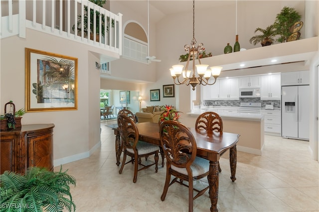 tiled dining area featuring high vaulted ceiling and a notable chandelier