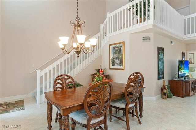 dining room with a towering ceiling and a chandelier