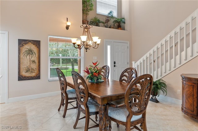 tiled dining room with a towering ceiling and a chandelier