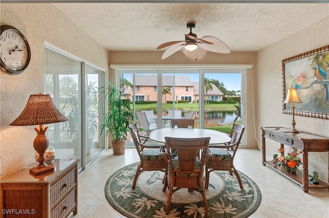 sunroom with ceiling fan, a water view, and a healthy amount of sunlight