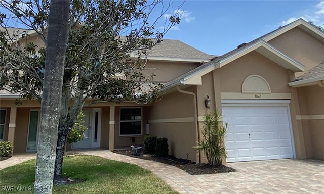 ranch-style home with stucco siding, driveway, and a garage