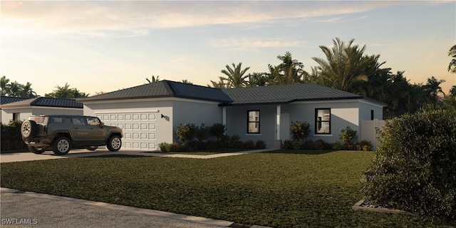 ranch-style home featuring a yard and a garage