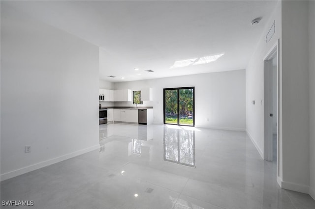 unfurnished living room with baseboards