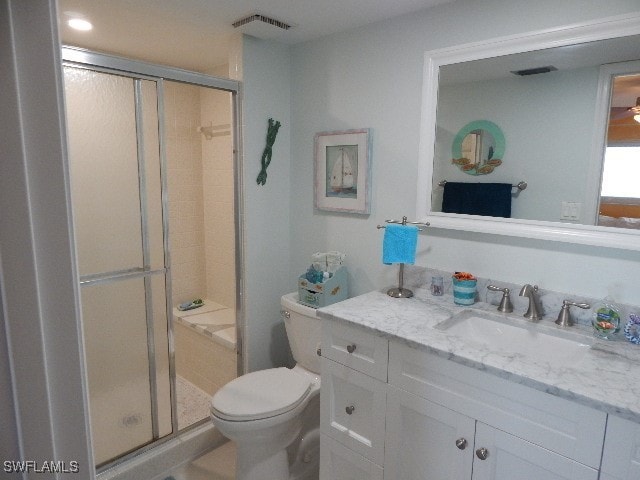 bathroom featuring vanity, toilet, and an enclosed shower