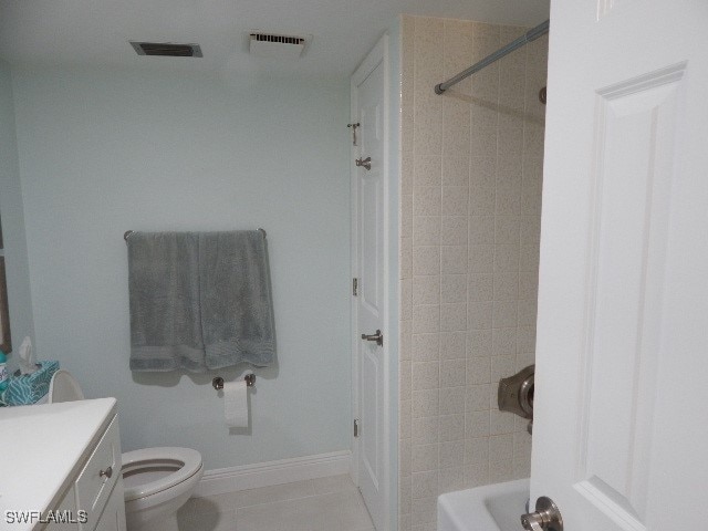 full bathroom with tiled shower / bath, vanity, toilet, and tile patterned floors