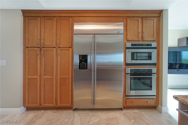 kitchen featuring stainless steel appliances and light stone countertops