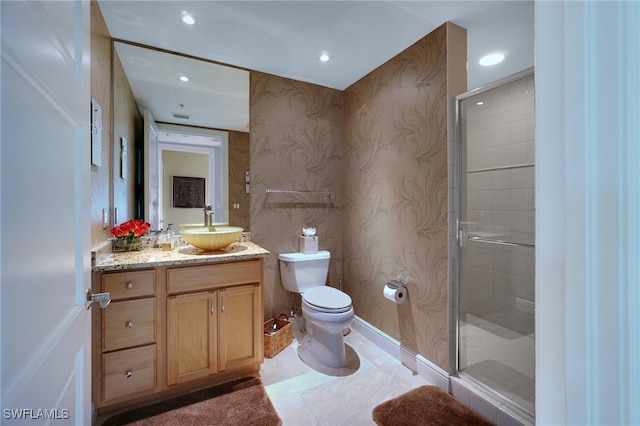 bathroom with vanity, toilet, and a shower with door