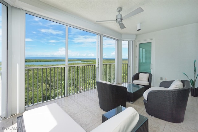 sunroom / solarium with a water view, ceiling fan, and plenty of natural light