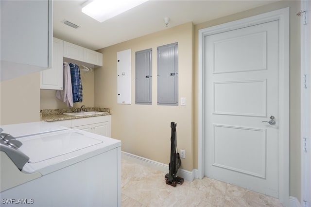 laundry room featuring electric panel, cabinets, sink, and washing machine and clothes dryer