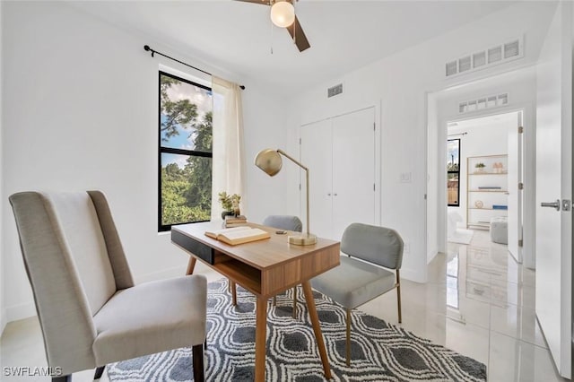 home office with light tile patterned floors and ceiling fan