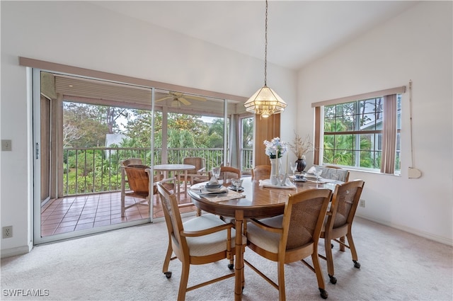 dining area featuring lofted ceiling, a wealth of natural light, and light colored carpet